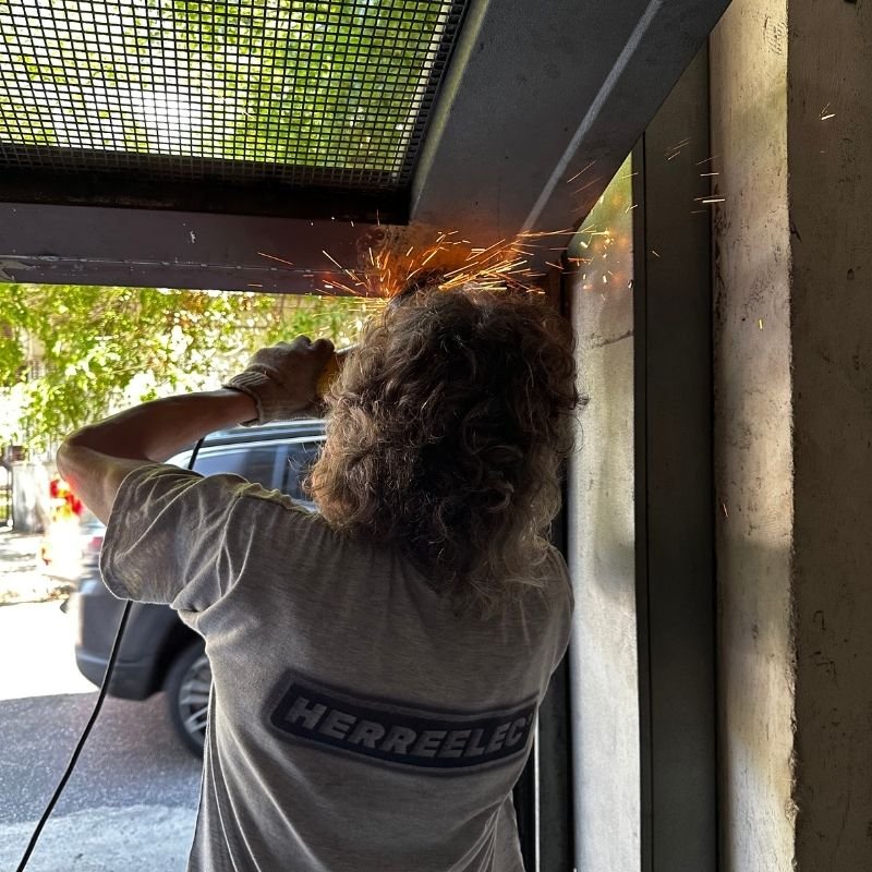 Se salió de guía — Cambio de rulemán y soporte en portón levadizo. Reemplazo del rulemán en la parte inferior derecha de un portón levadizo. Se cambiaron el perno, el soporte del rulemán y el rulemán para optimizar su funcionamiento. Trabajo realizado por HERREELEC.